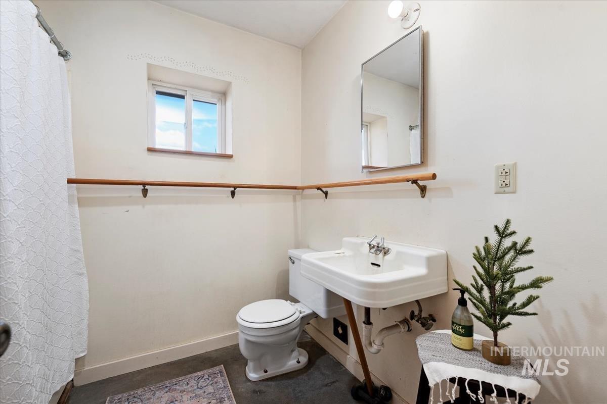 Full bath with toilet and baseboards