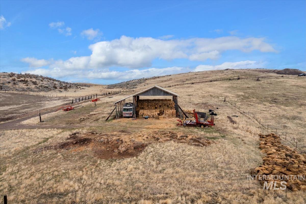 View of yard featuring a view of rural / pastoral area, a carport, a mountain view, and an outdoor structure
