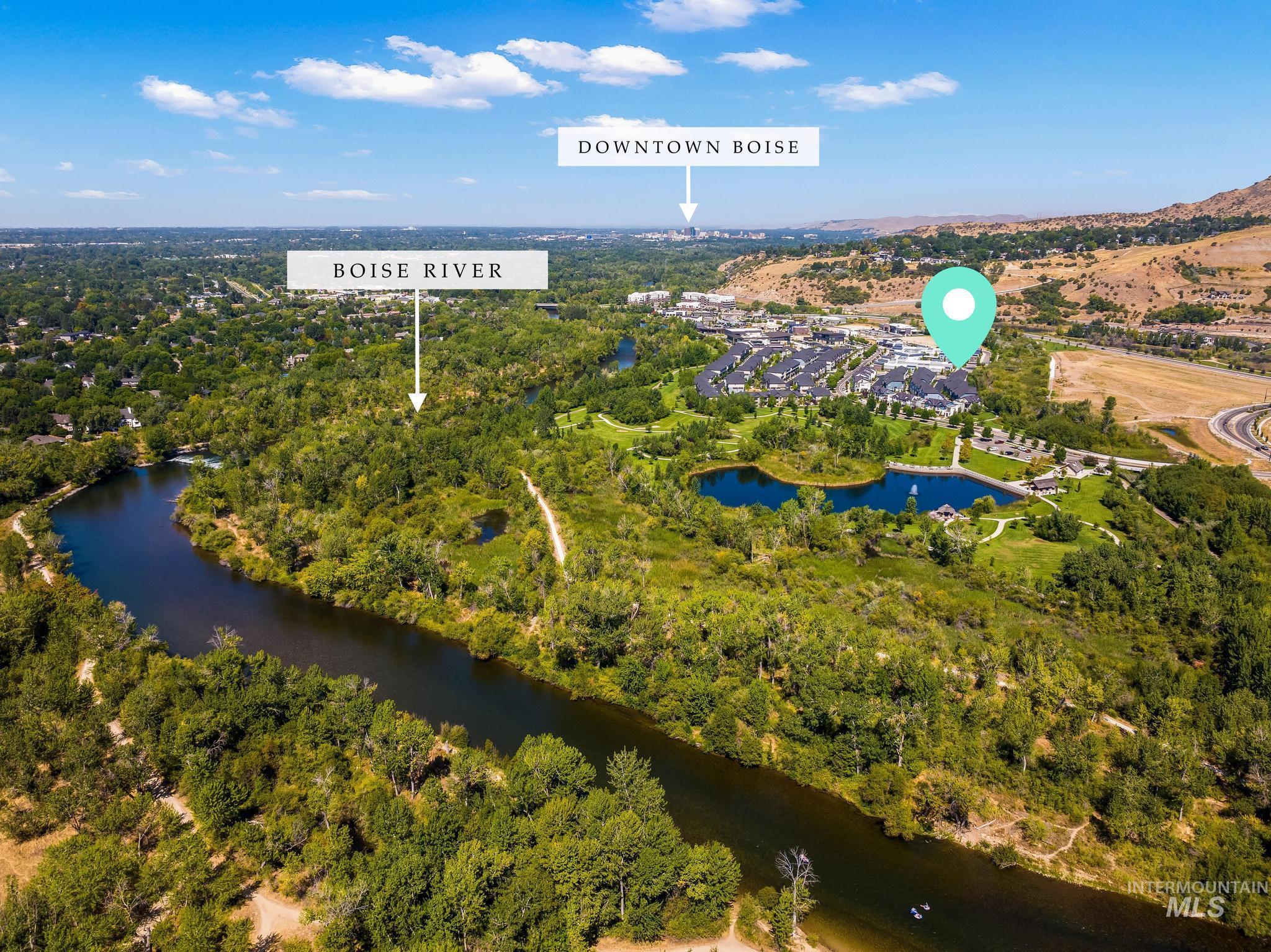 Aerial view of property's location featuring a large body of water and a heavily wooded area