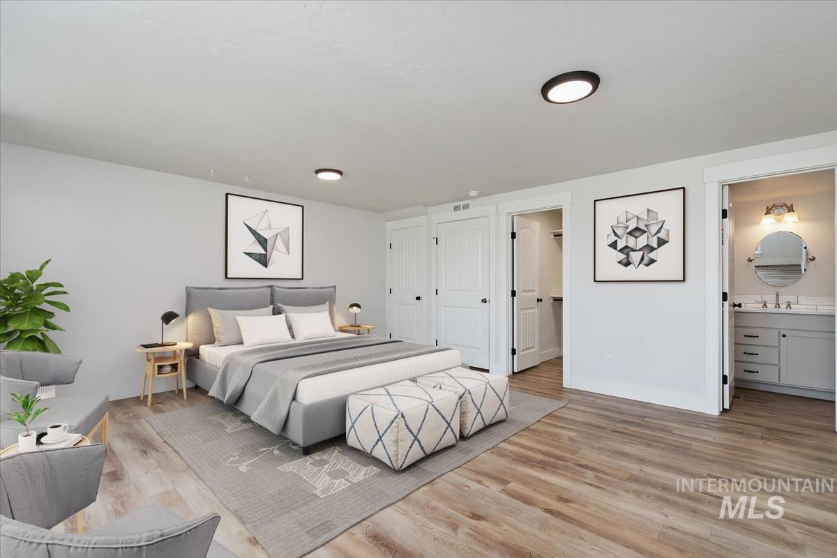 Spacious bedroom featuring wood-finish flooring and neutral wall tones