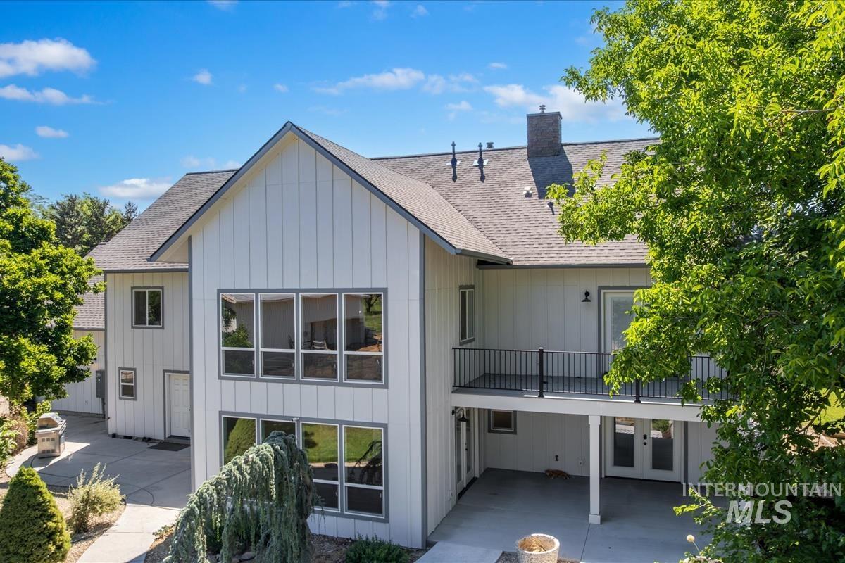 Modern farmhouse-style exterior with white board and batten siding, gray trim, and a gabled roof