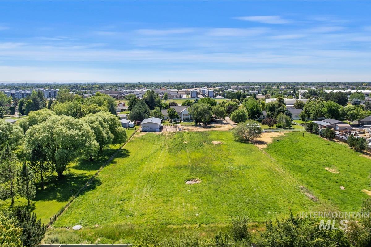 Expansive green parcel with perimeter fencing and a wooded border