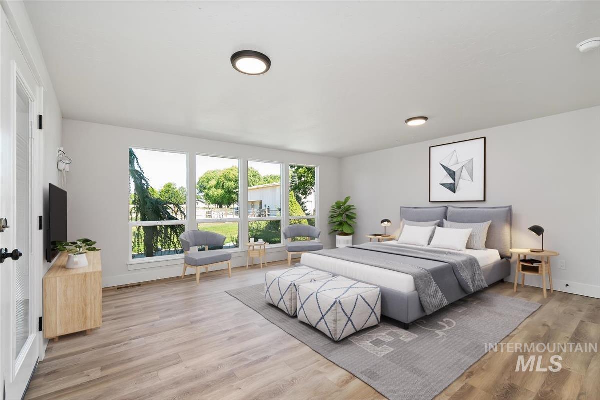 Spacious room featuring wood-finish flooring, a wall of large windows, and recessed lighting