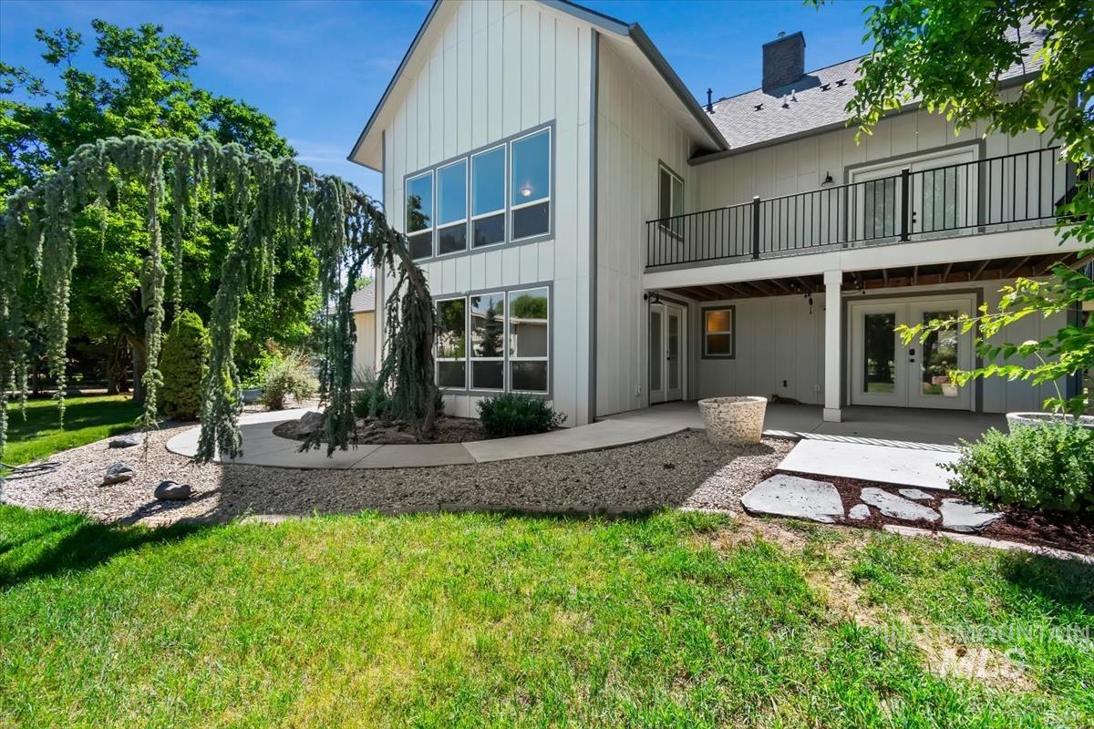White vertical siding exterior with extensive window placements and a balcony featuring black railings