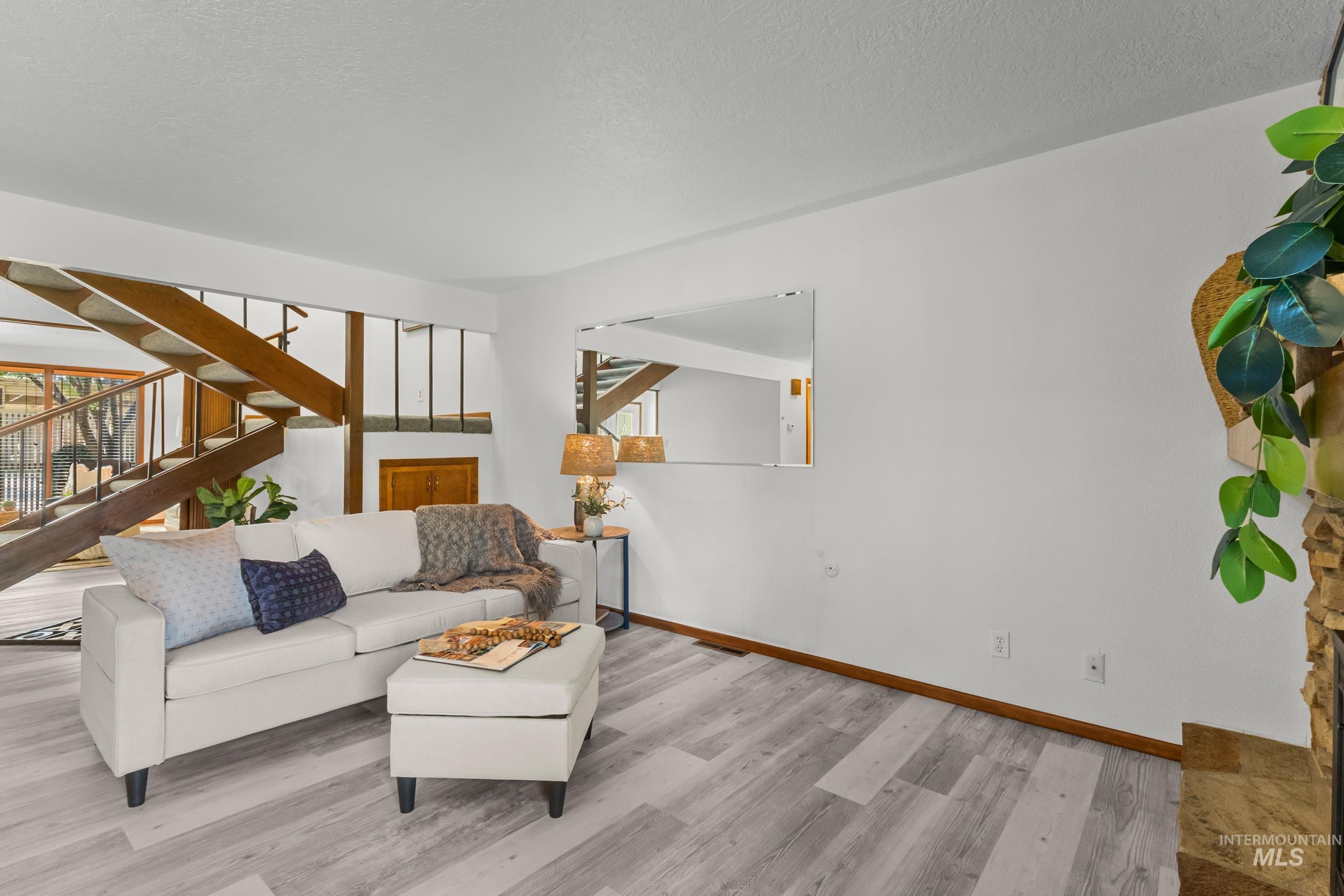 Living area featuring stairs, wood finished floors, and a textured ceiling