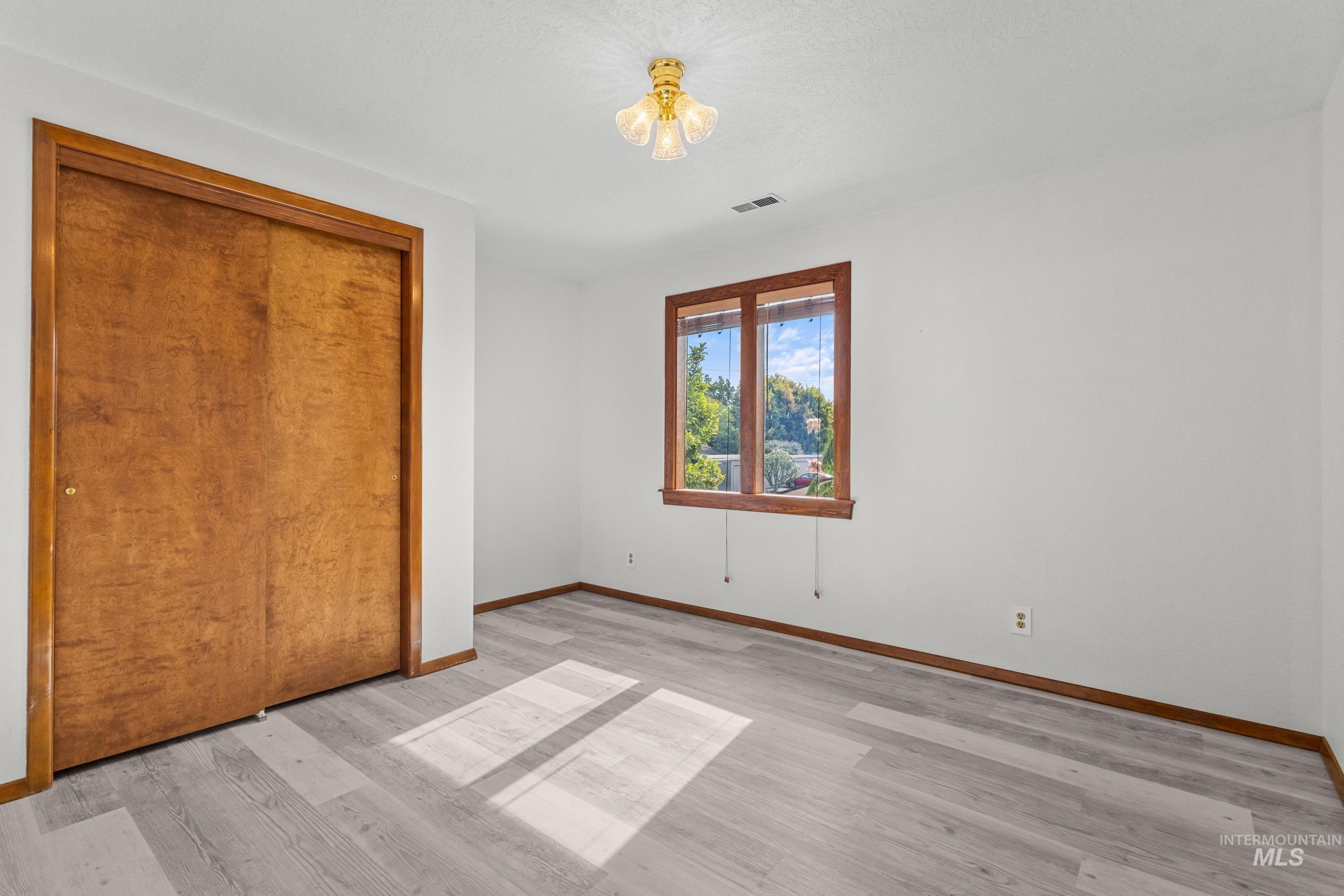 Unfurnished bedroom featuring light wood finished floors and a closet