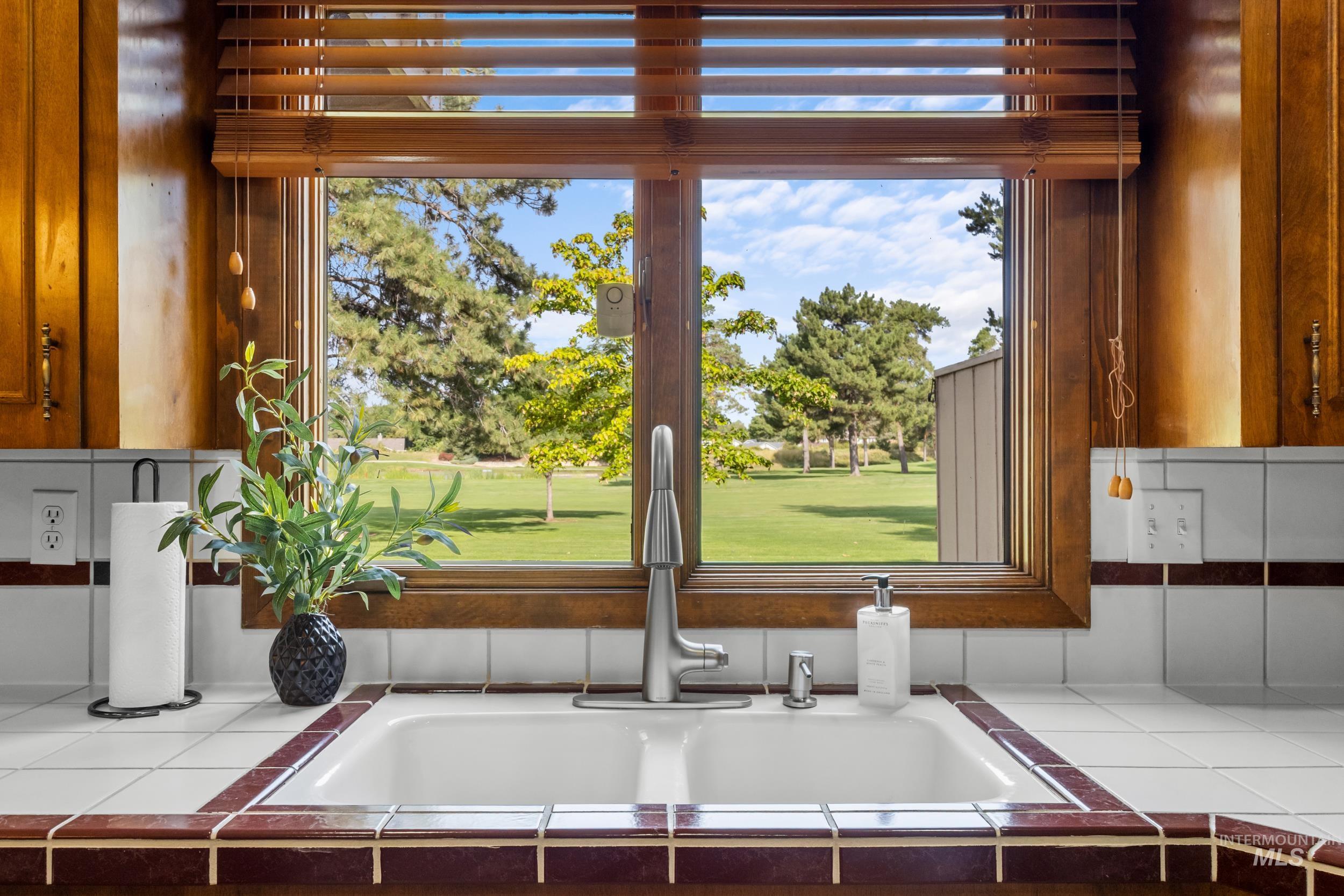 Kitchen view of tile counters and brown cabinets