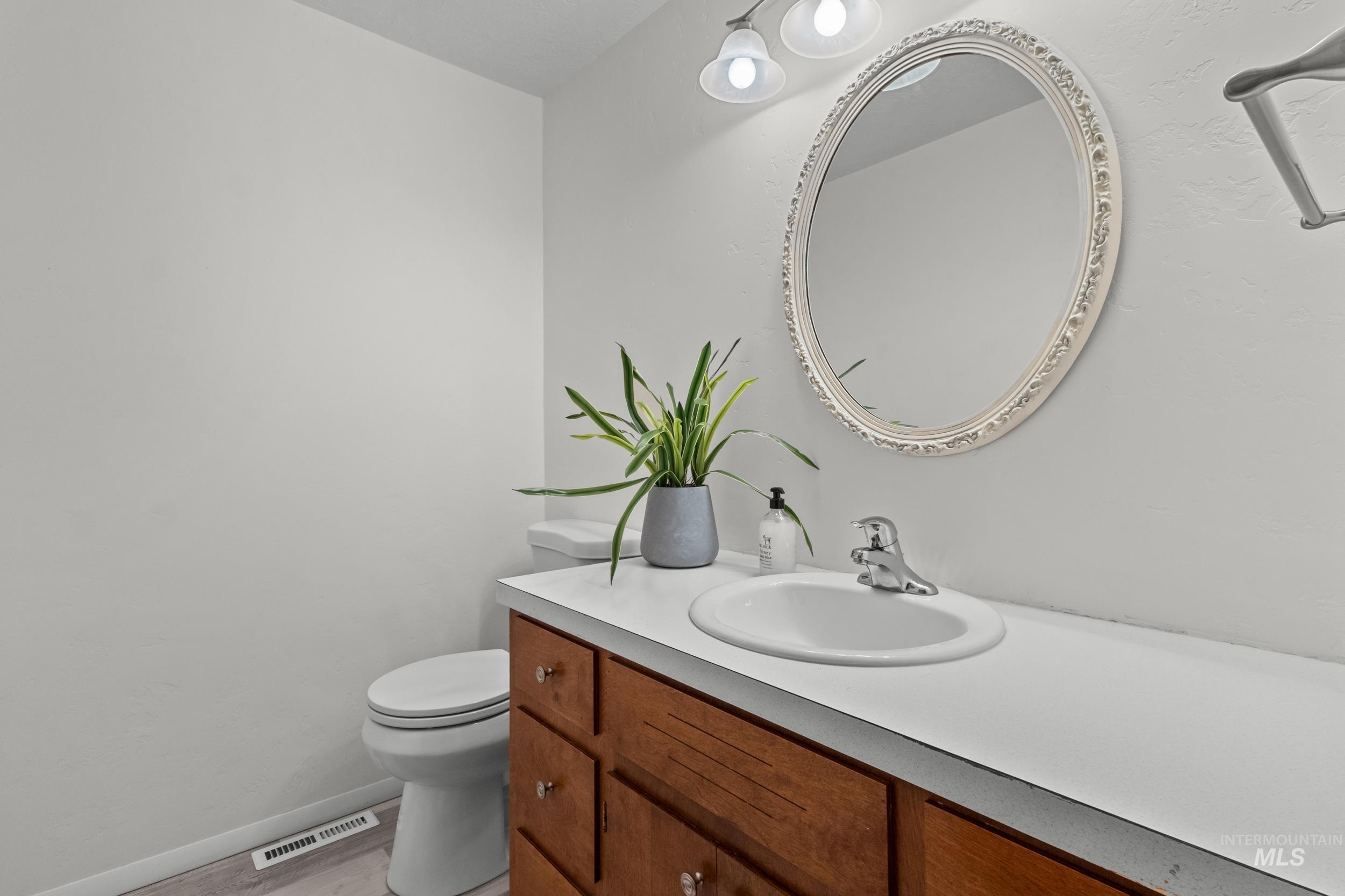 Half bath with vanity and light wood finished floors