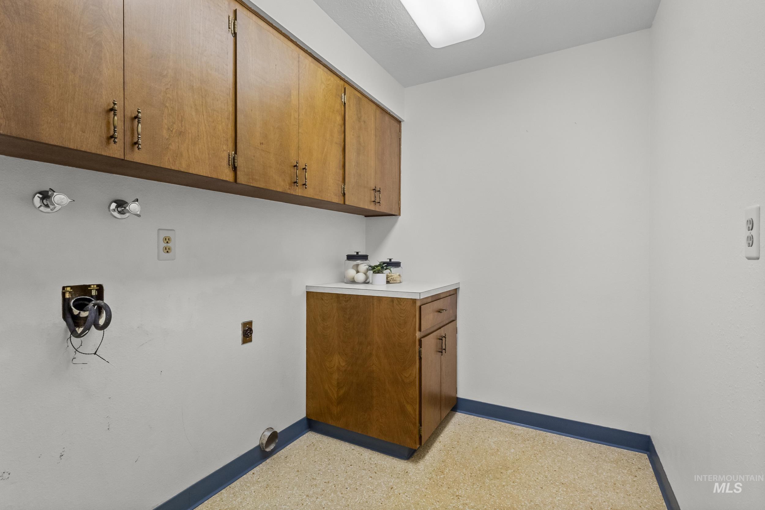 Washroom featuring baseboards and cabinet space