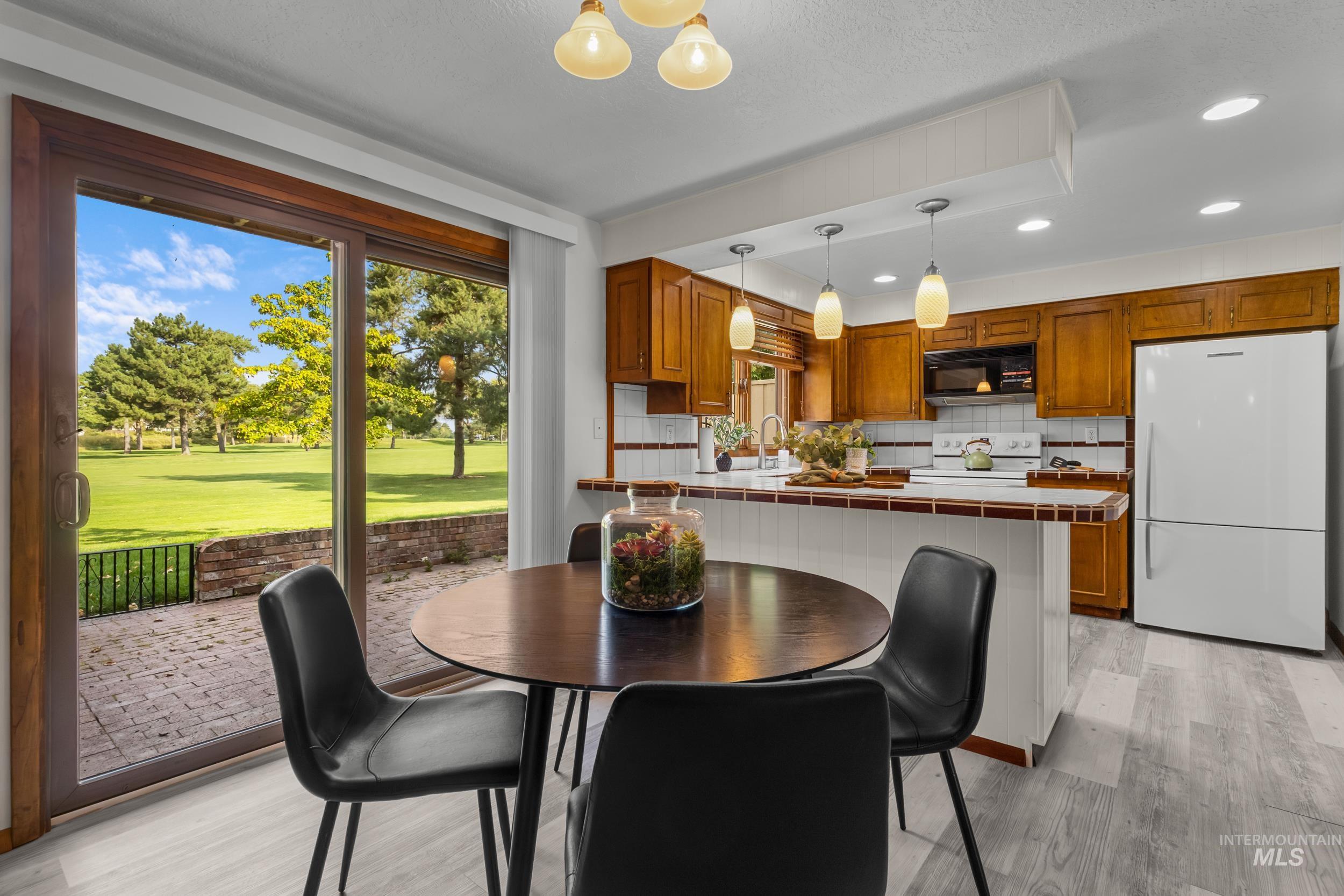 Dining room featuring light wood finished floors, recessed lighting, and a chandelier