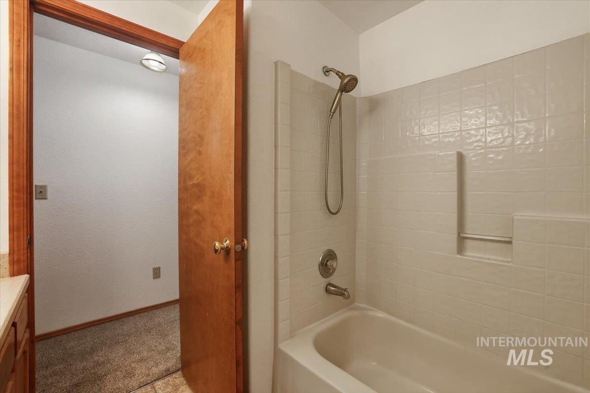 Bathroom featuring bathtub / shower combination and vanity