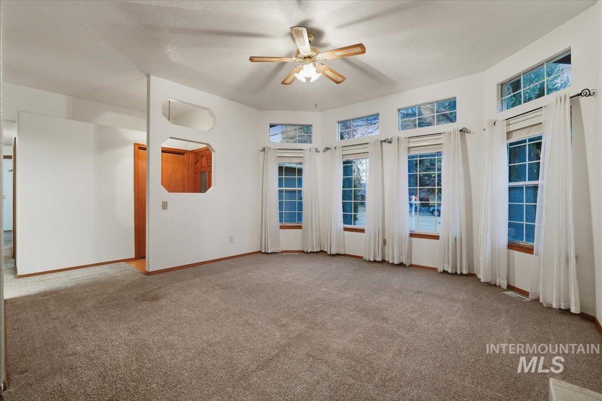 Spare room with carpet, a textured ceiling, and ceiling fan