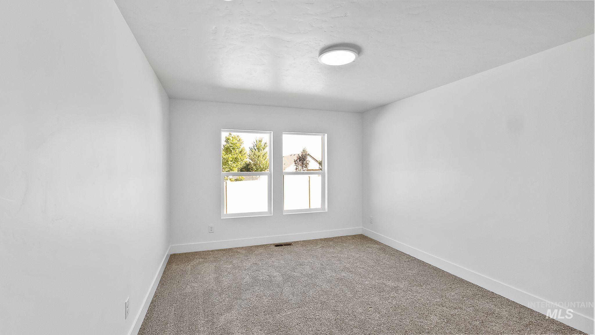 Empty room featuring carpet flooring and baseboards