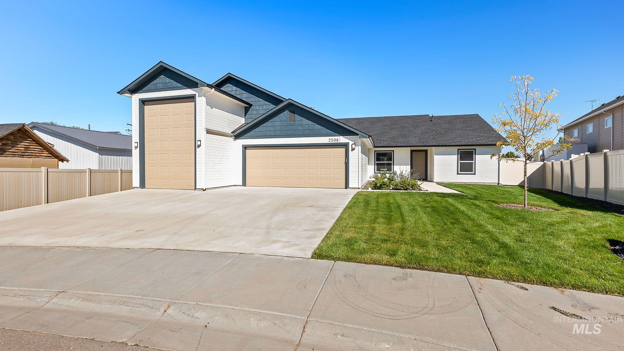 View of front facade featuring driveway and an attached garage