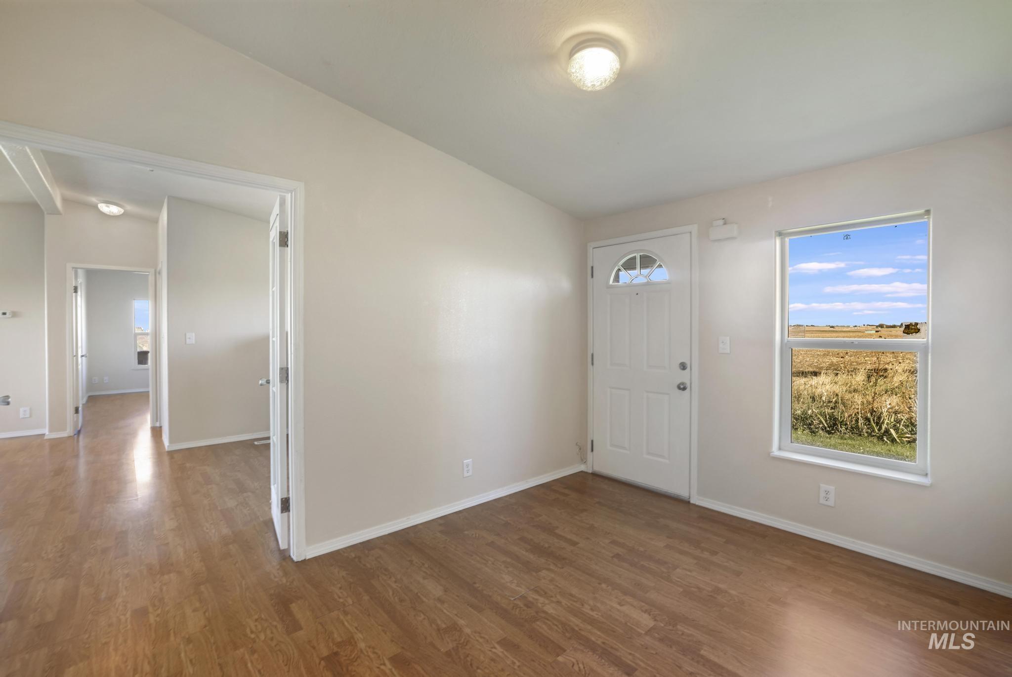 Foyer entrance with wood finished floors and lofted ceiling