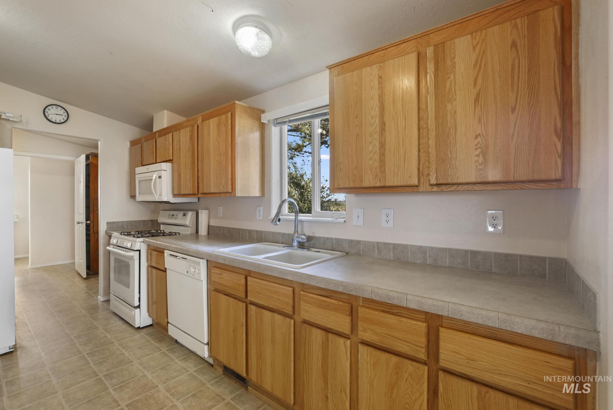 Kitchen featuring white appliances and light countertops