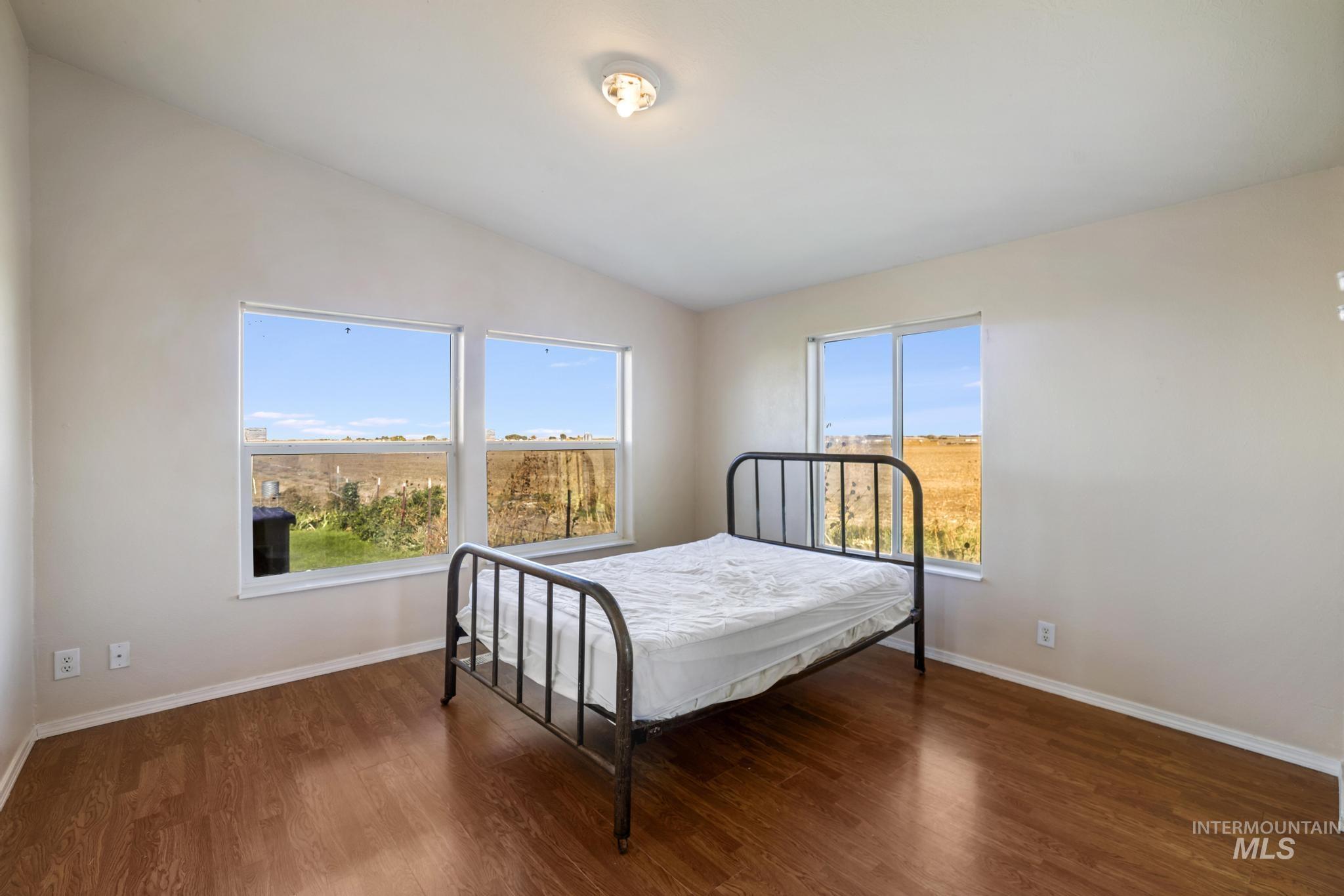 Bedroom featuring dark wood-style flooring and lofted ceiling
