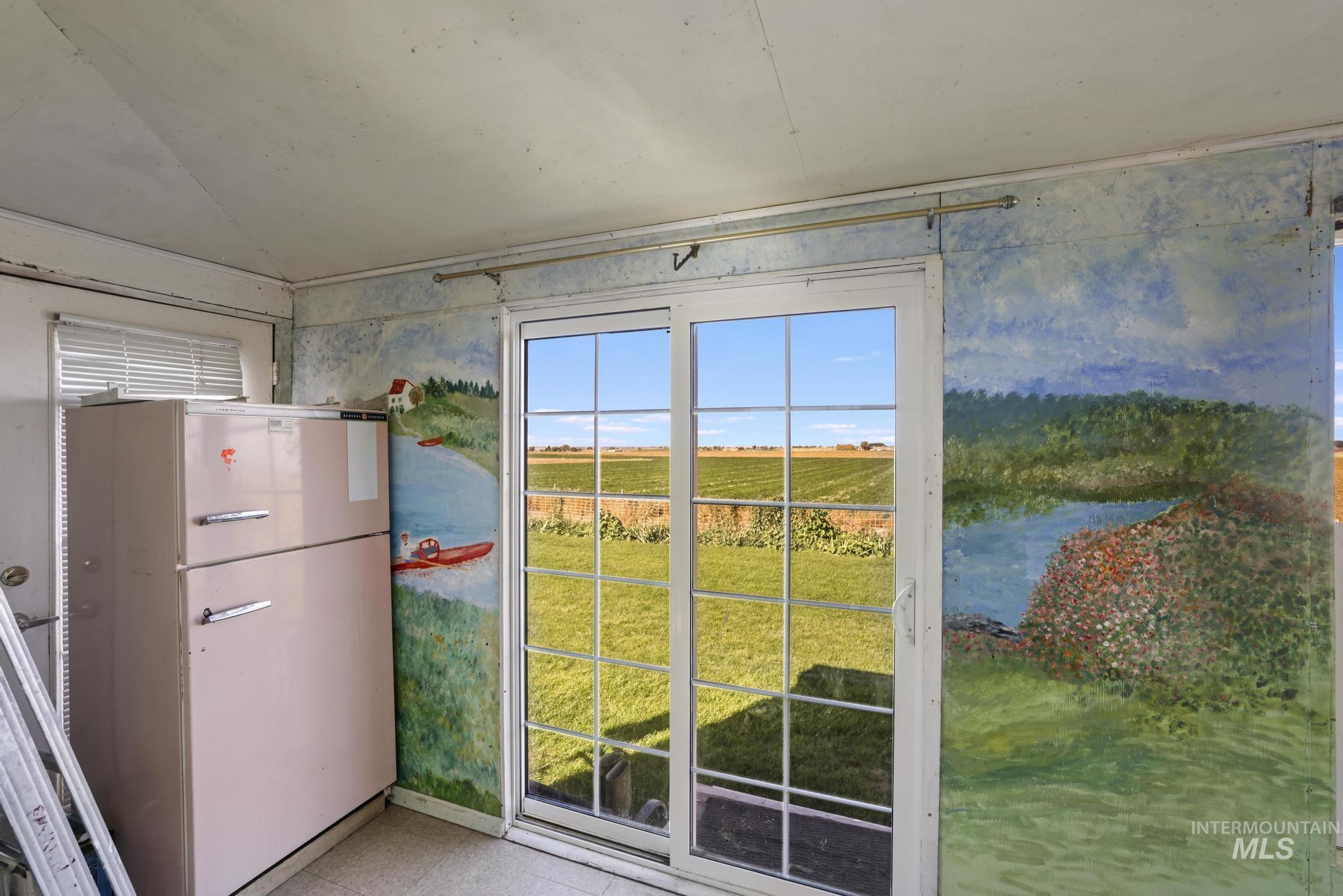 Doorway featuring baseboards and wallpapered walls