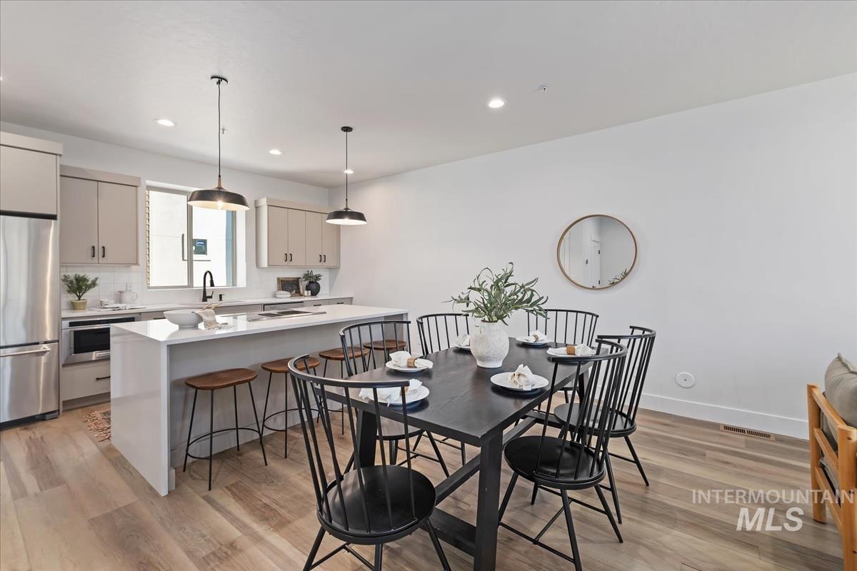 Dining room with light wood-type flooring and recessed lighting