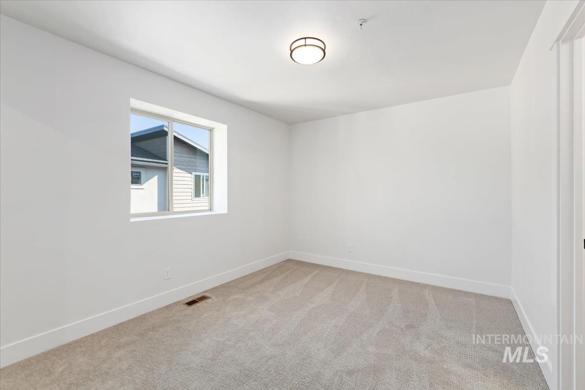 Unfurnished room featuring carpet and fire sprinkler in ceiling