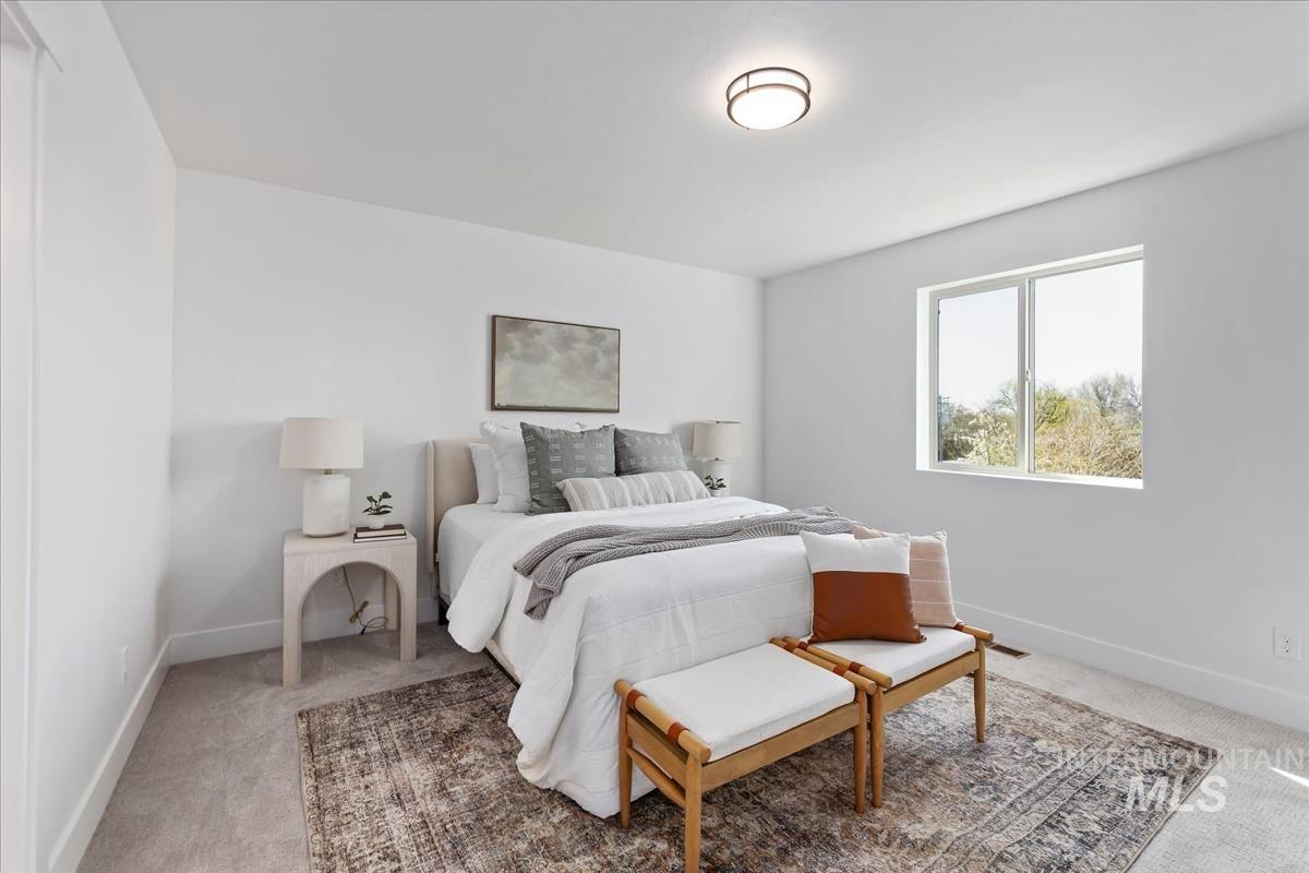 Bedroom featuring light colored carpet and baseboards