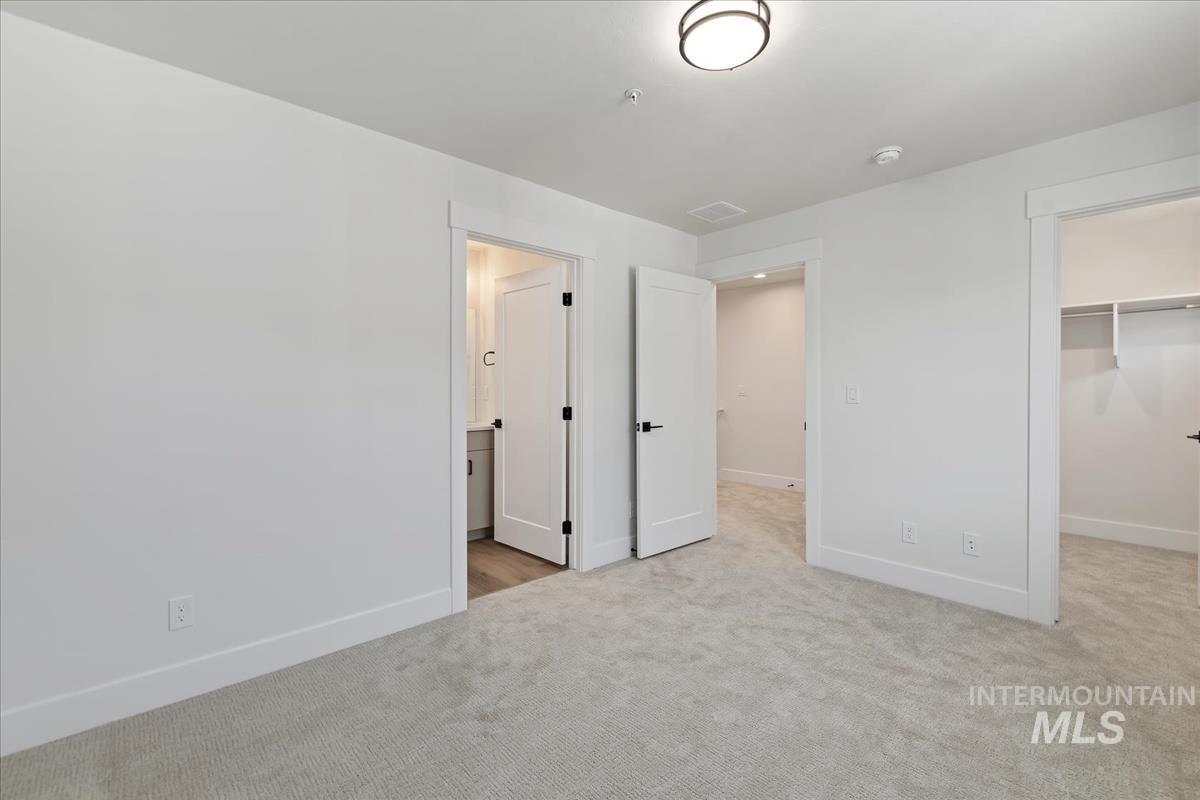 Unfurnished bedroom with carpet flooring, a spacious closet, and a closet