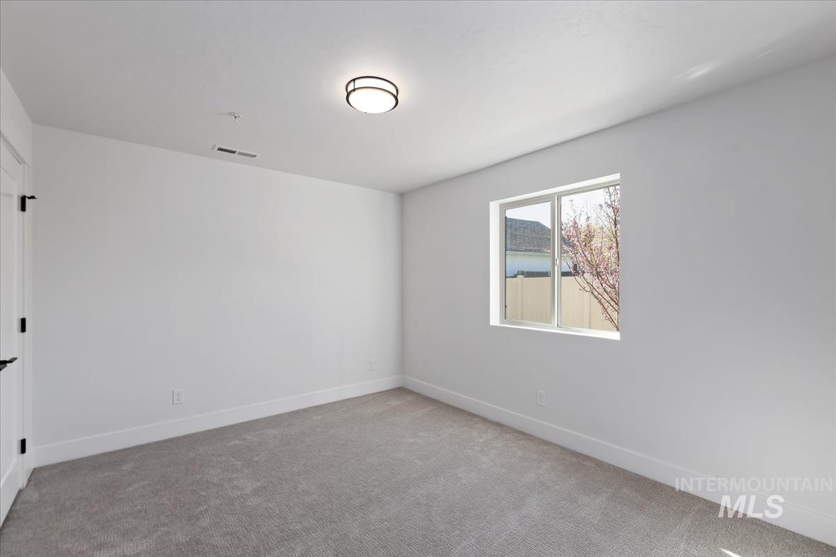 Carpeted spare room with baseboards