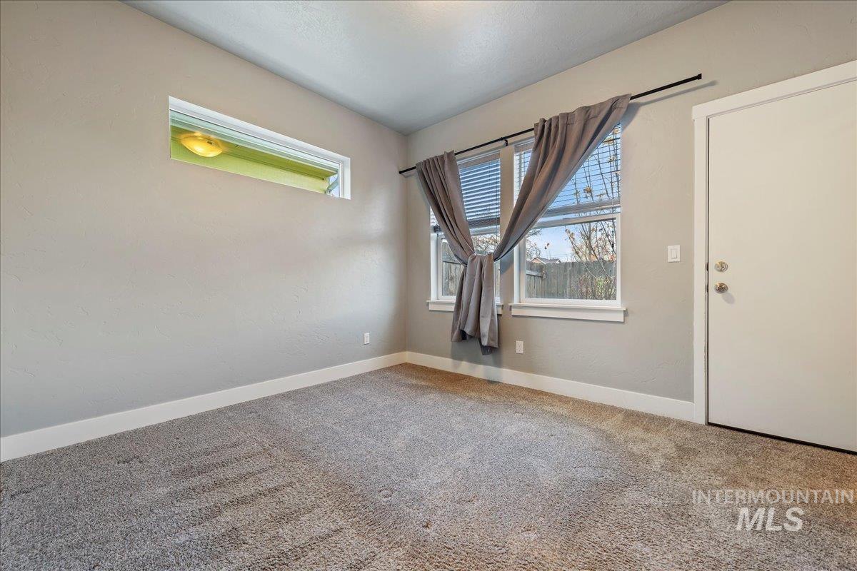 Carpeted spare room featuring baseboards