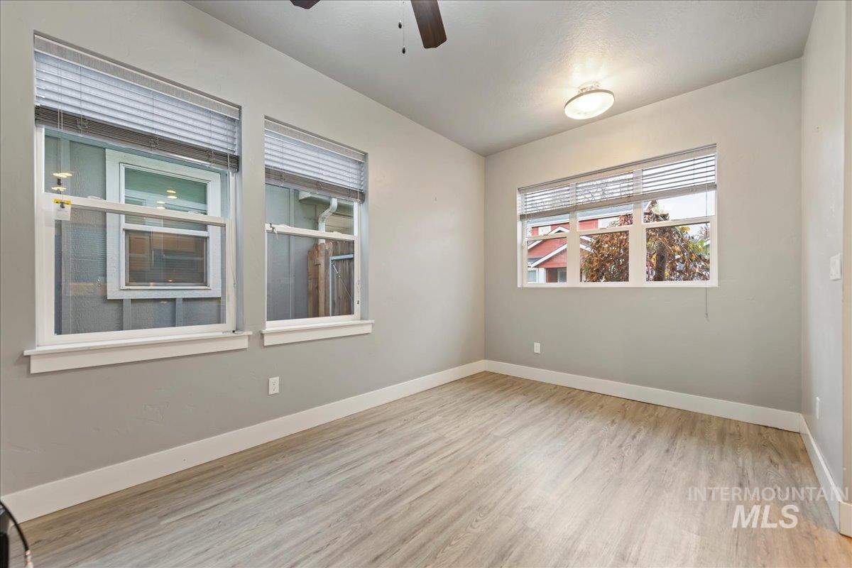 Unfurnished room with light wood finished floors and a ceiling fan