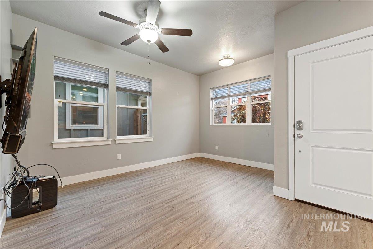Empty room featuring light wood-style flooring and ceiling fan