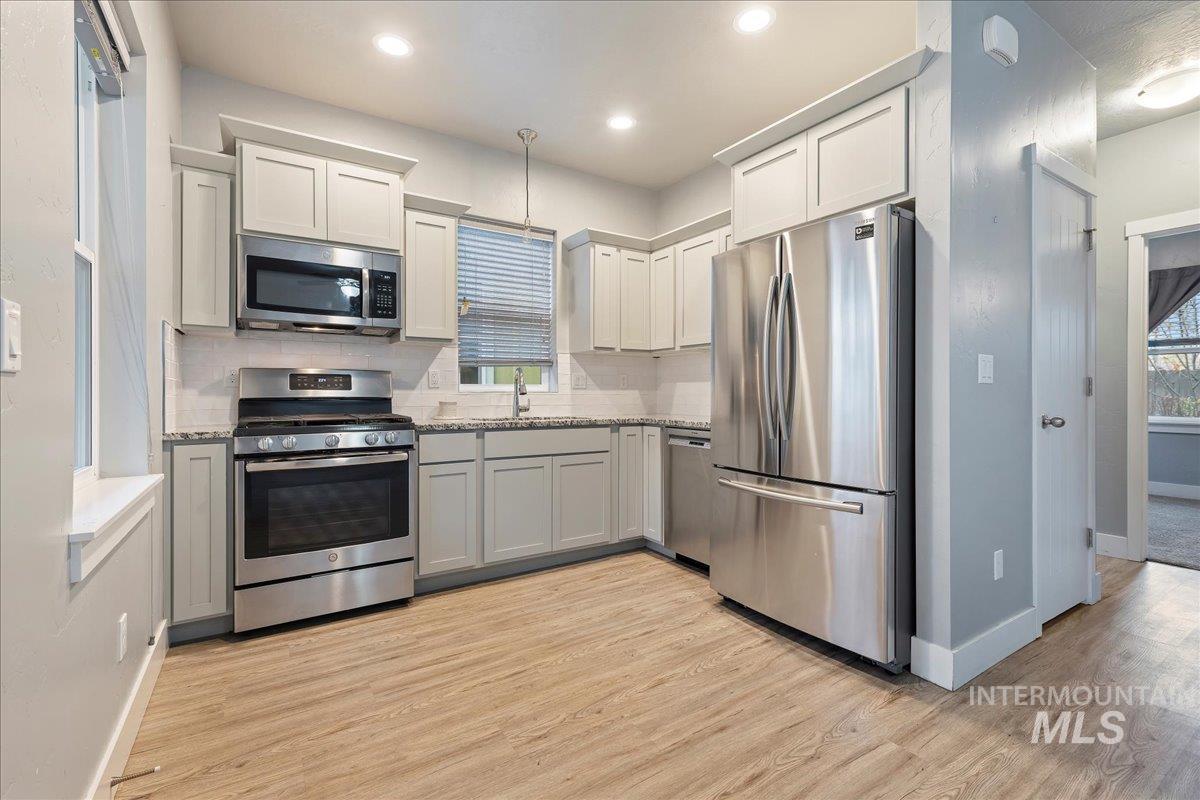 Kitchen featuring stainless steel appliances, light wood-style floors, white cabinets, and recessed lighting