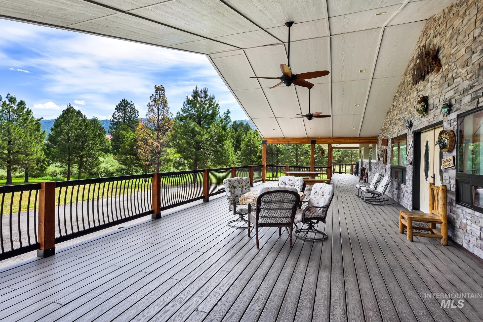 Trex Deck terrace featuring outdoor lounge area, ceiling fans and view of wooded front acreage