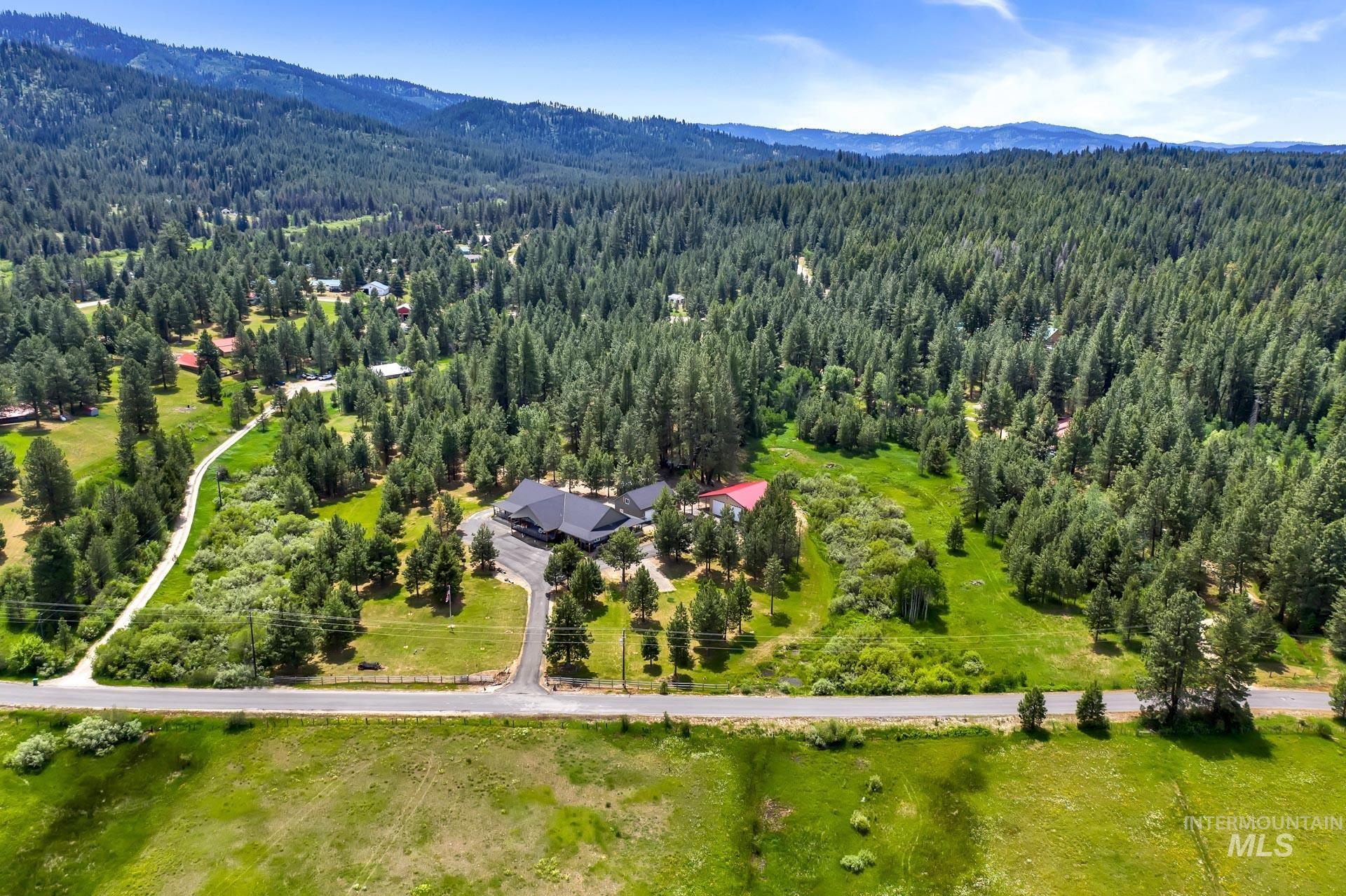 Bird's eye view of a heavily wooded area and a mountainous background