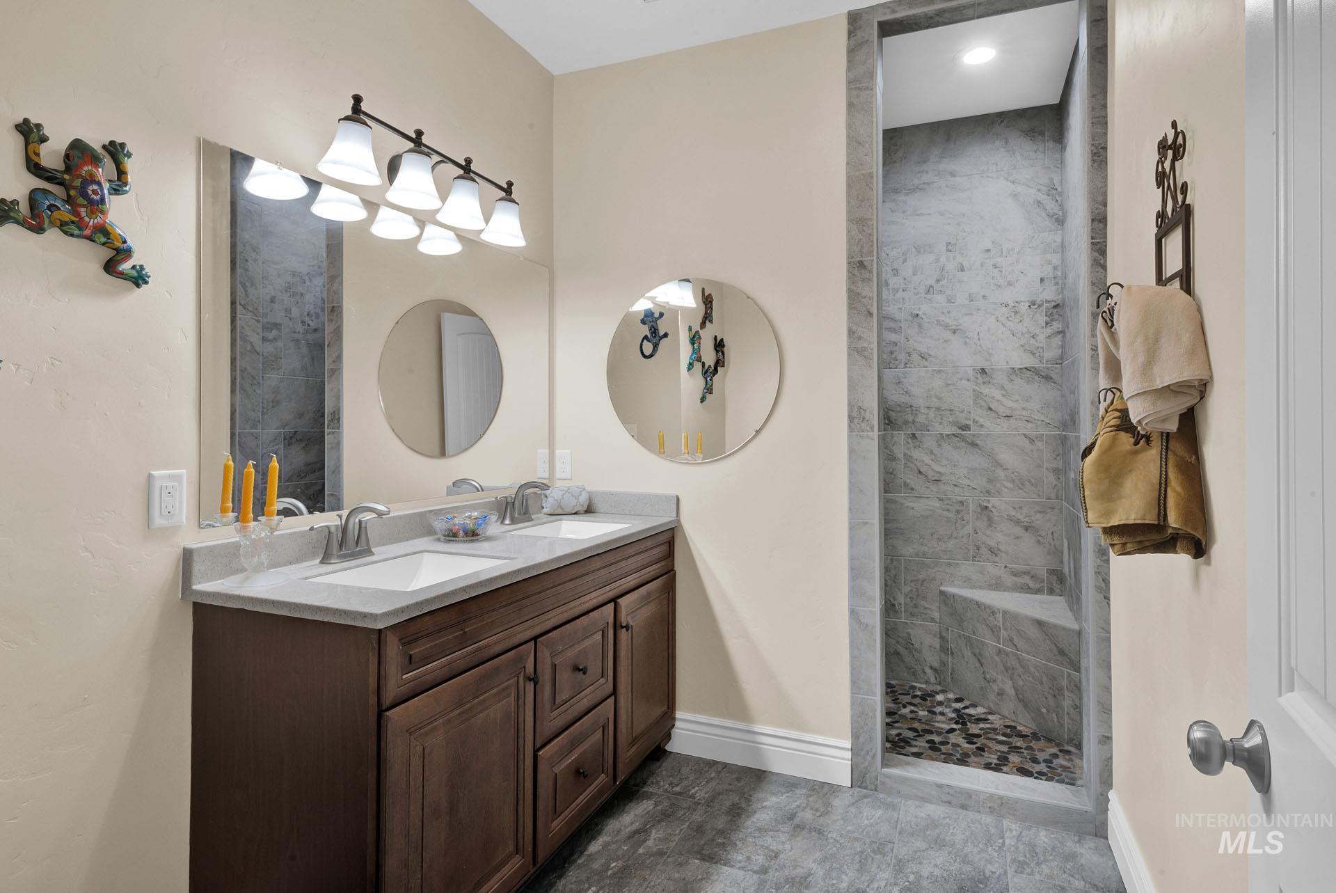 Bathroom with oversized vanity that includes double vanities and a tiled walk in shower and seat
