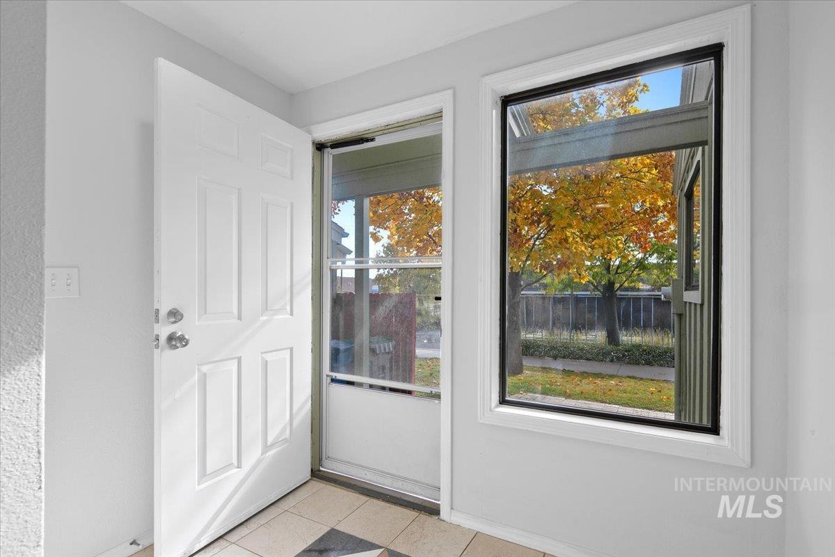 Doorway to outside with tile patterned floors and baseboards