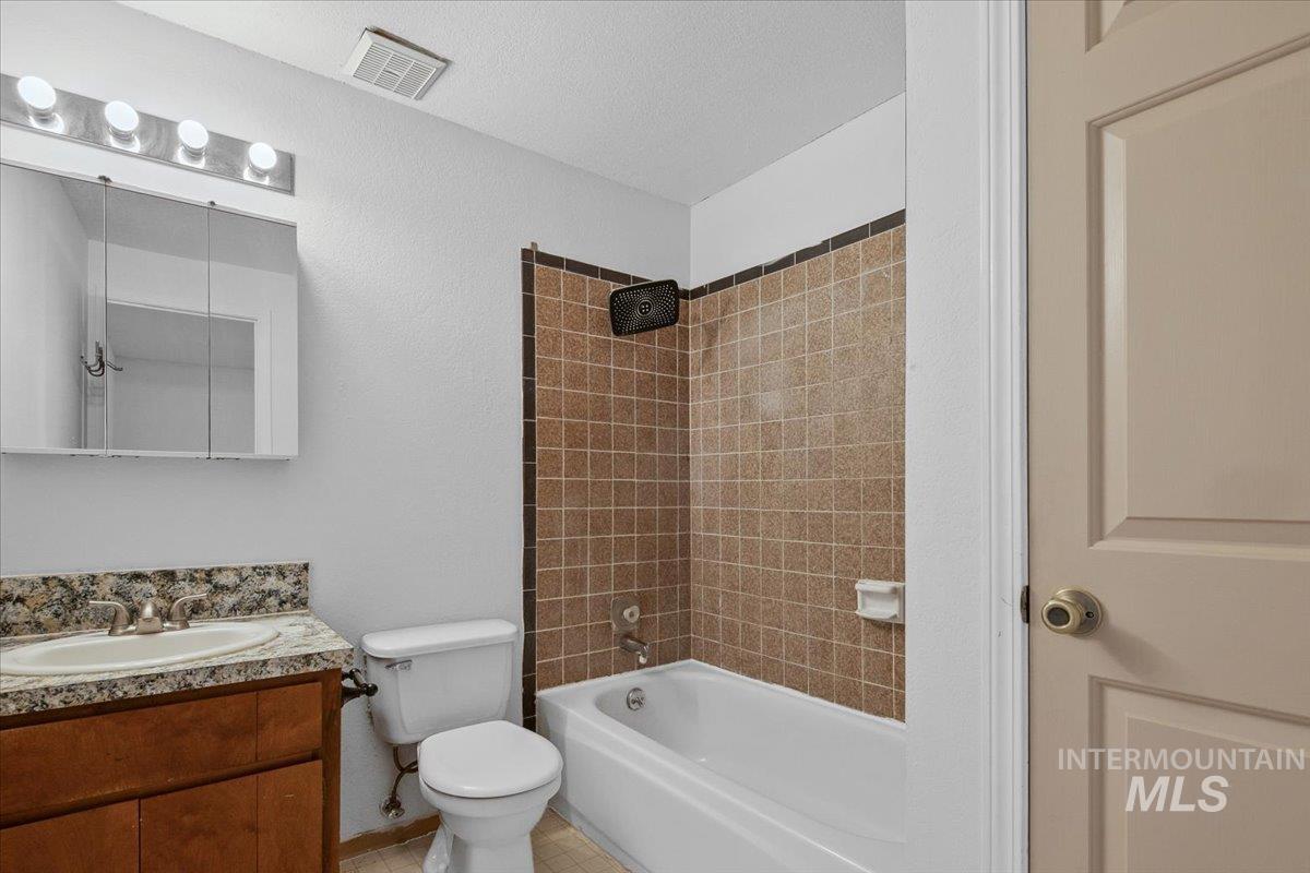 Full bath featuring shower / bath combination, vanity, and light tile patterned floors