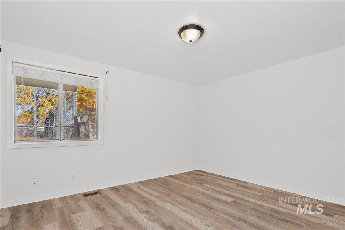 Unfurnished room featuring wood finished floors and baseboards
