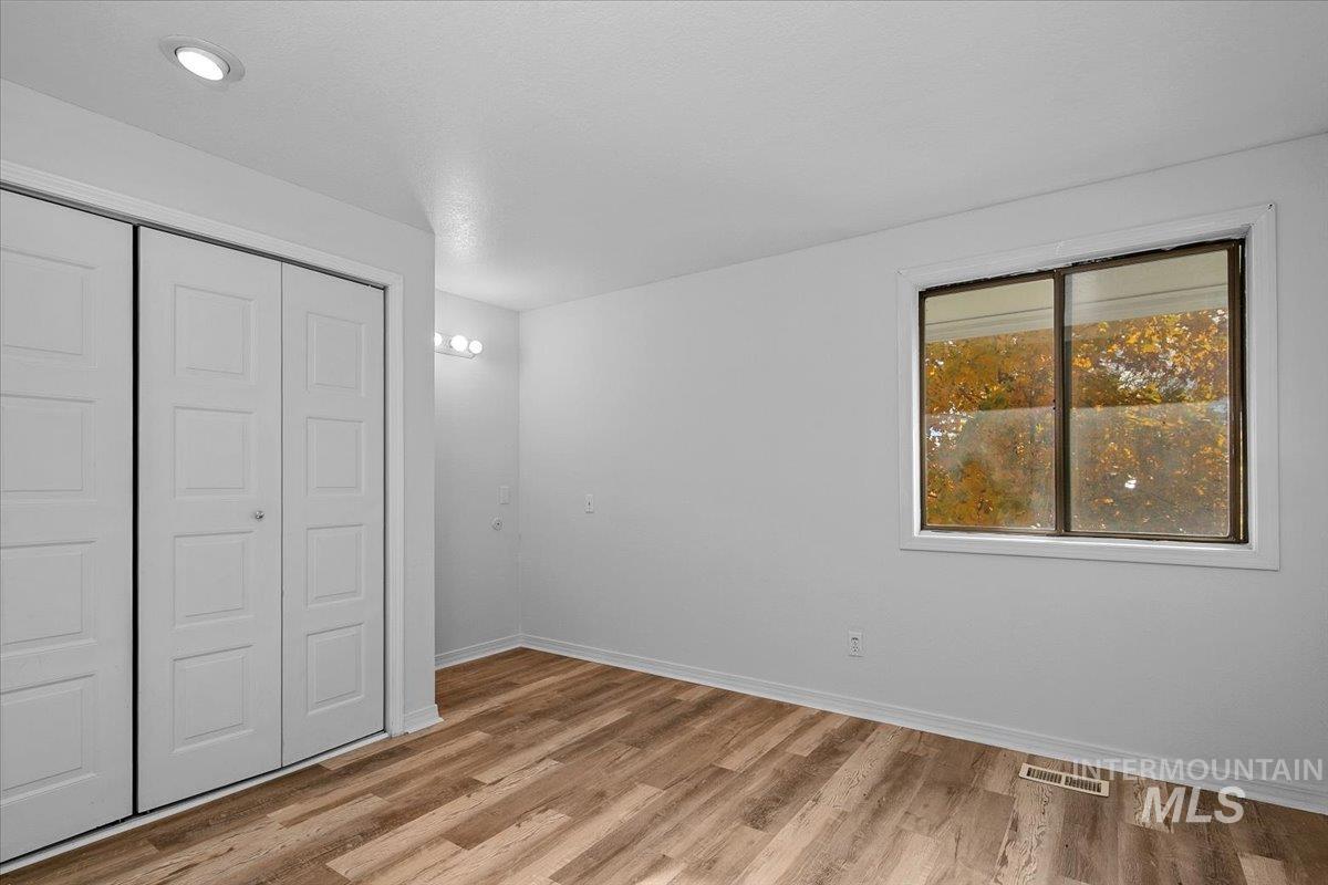 Unfurnished bedroom with a closet and light wood-type flooring