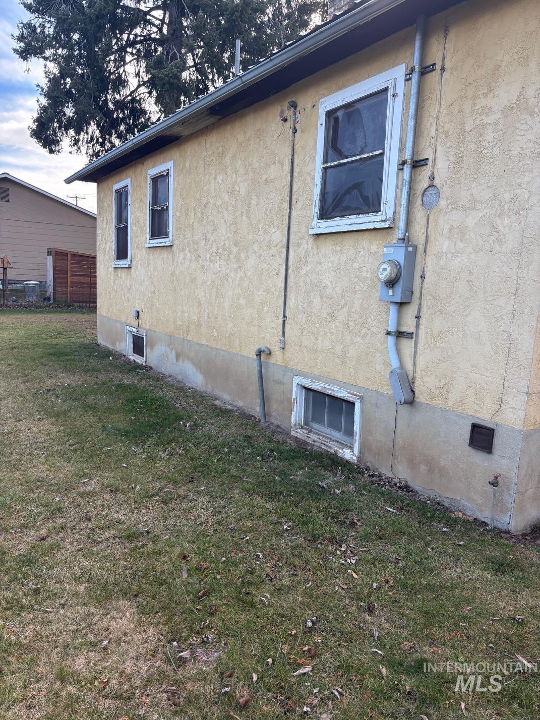 View of home's exterior featuring a lawn and stucco siding