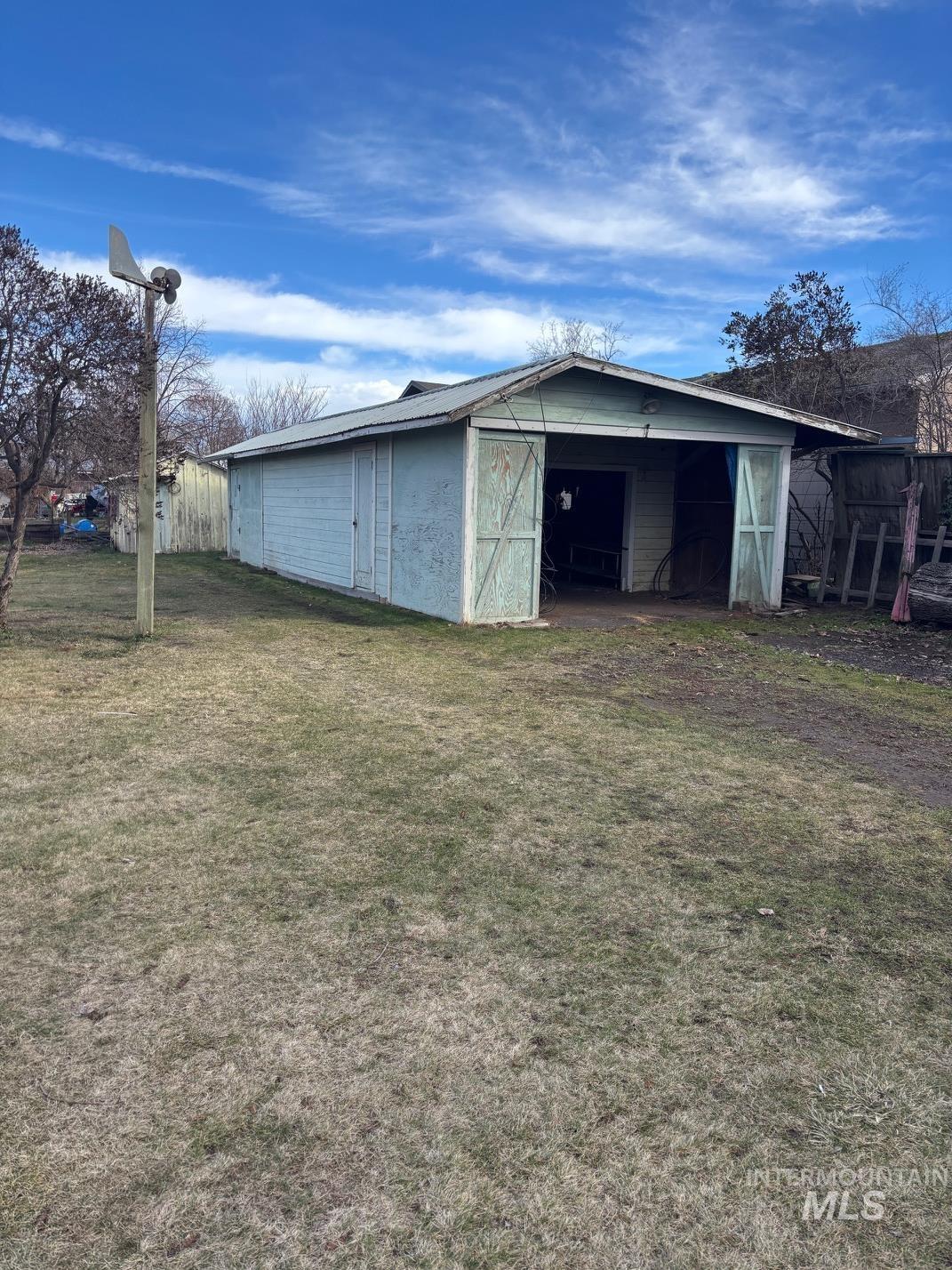 View of pole building with a yard