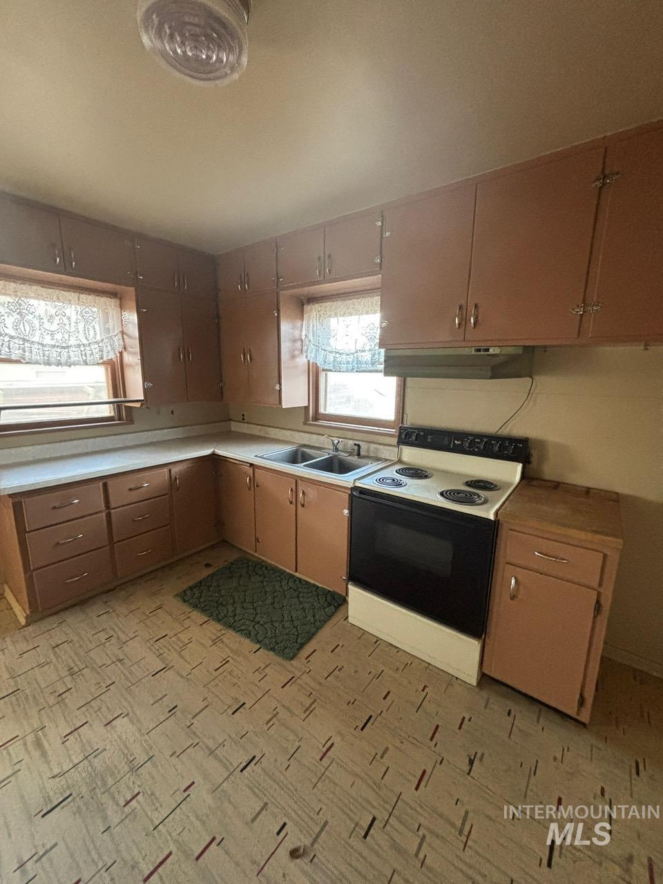 Kitchen with range with electric stovetop and light countertops