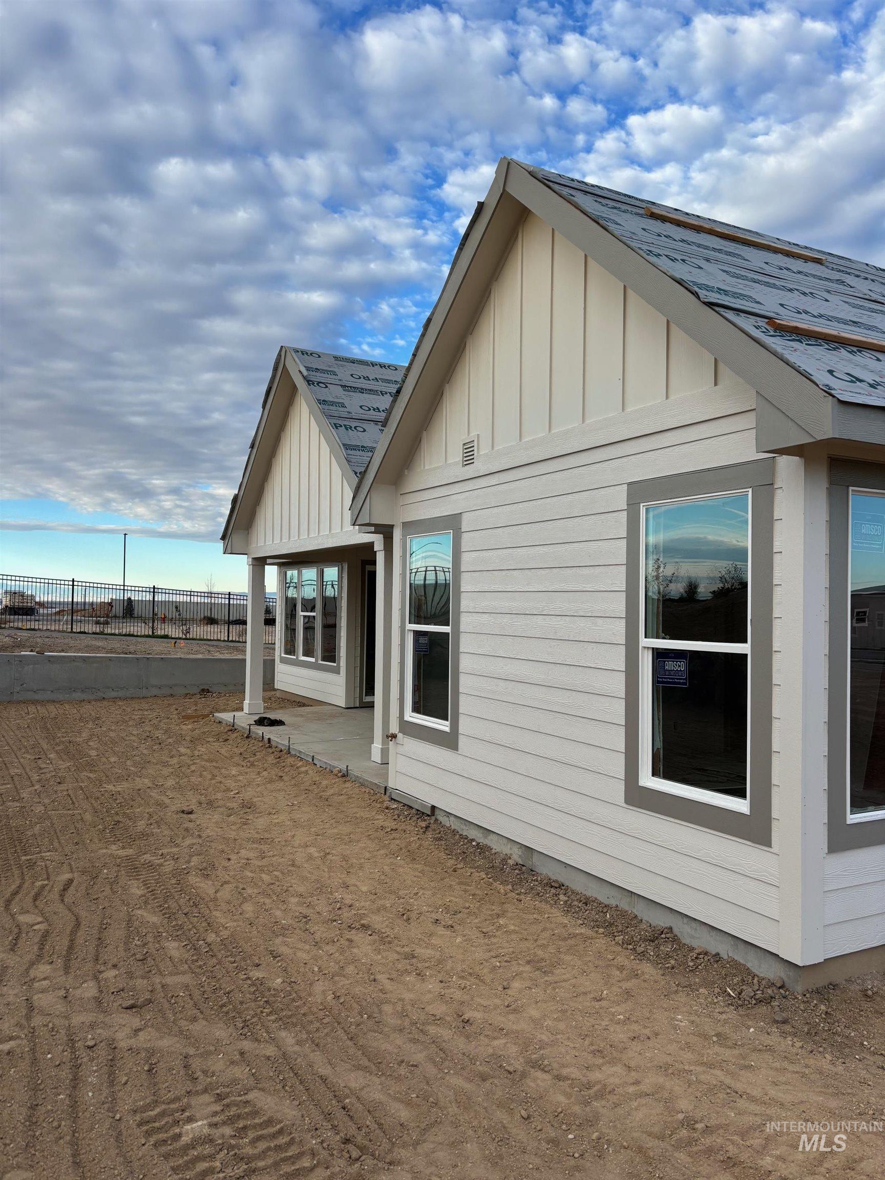 View of home's exterior featuring board and batten siding, a patio area, and a shingled roof