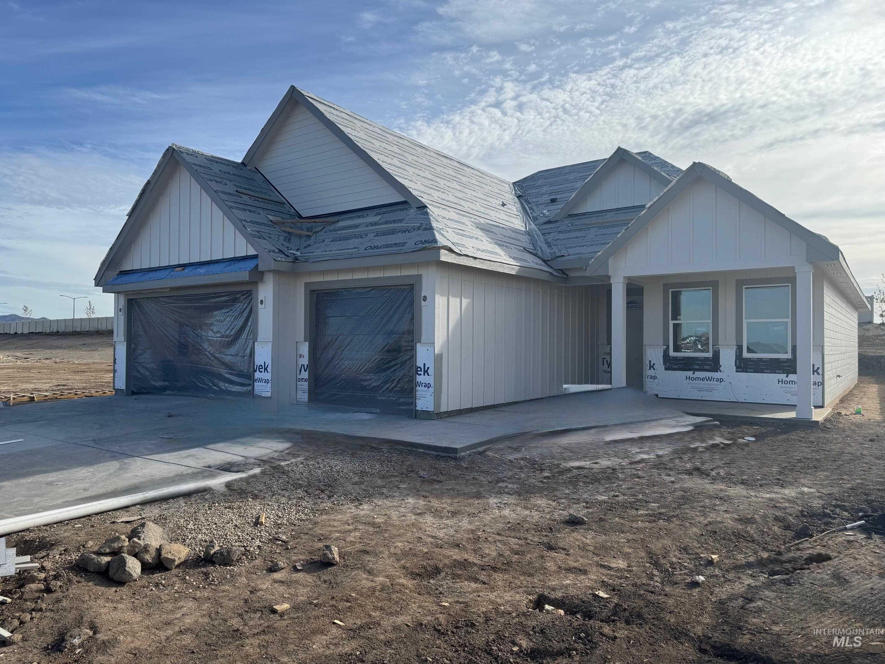 View of front of house with driveway, an attached garage, and board and batten siding