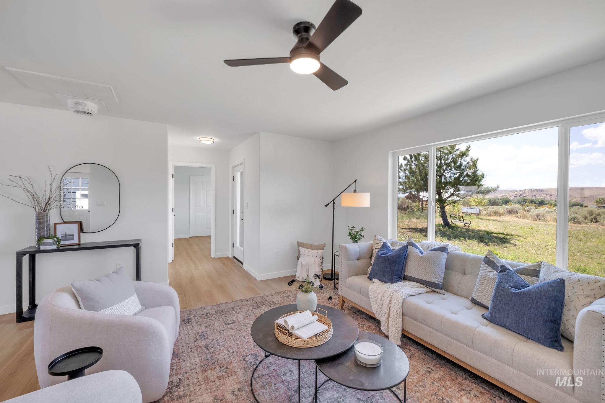 Living room with light wood finished floors and a ceiling fan
