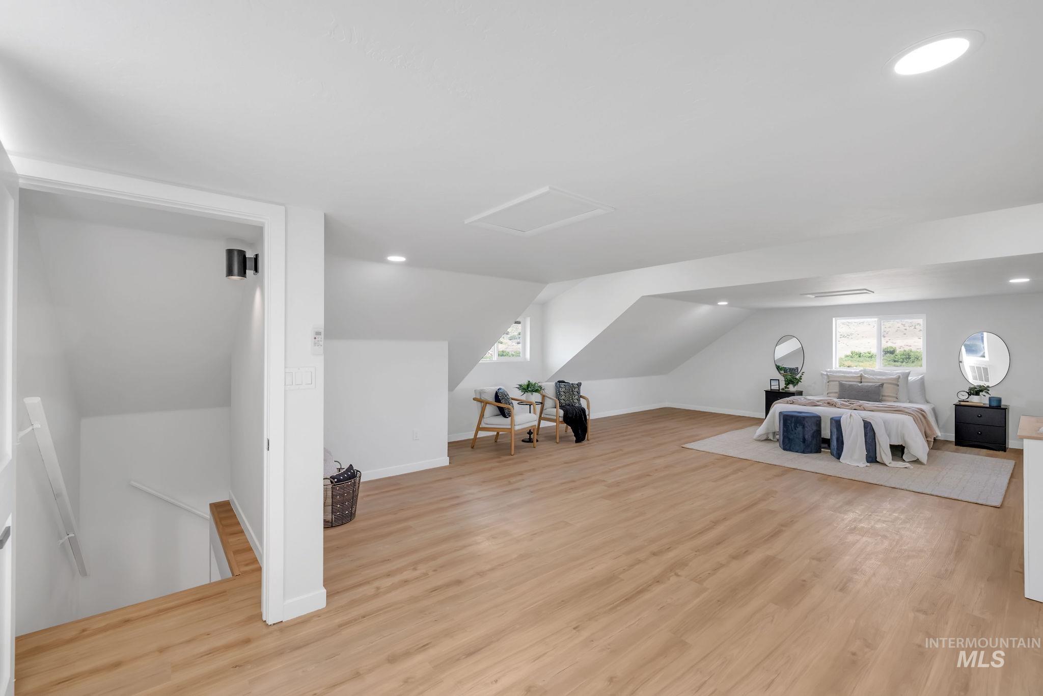Additional living space featuring recessed lighting, lofted ceiling, attic access, and light wood-style floors