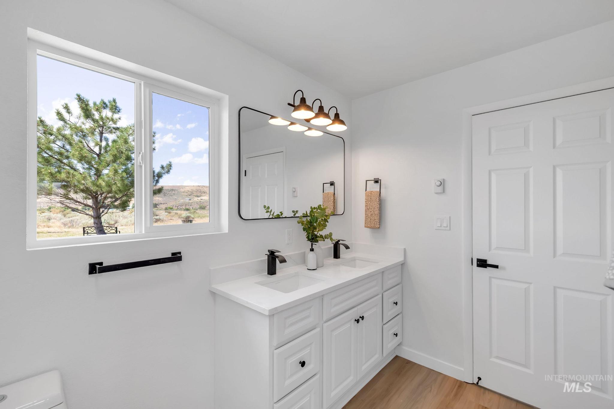 Bathroom with double vanity and wood finished floors