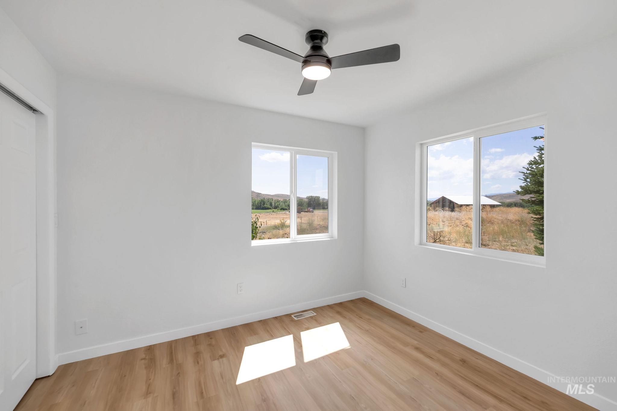 Unfurnished bedroom featuring light wood-style floors, a closet, and ceiling fan