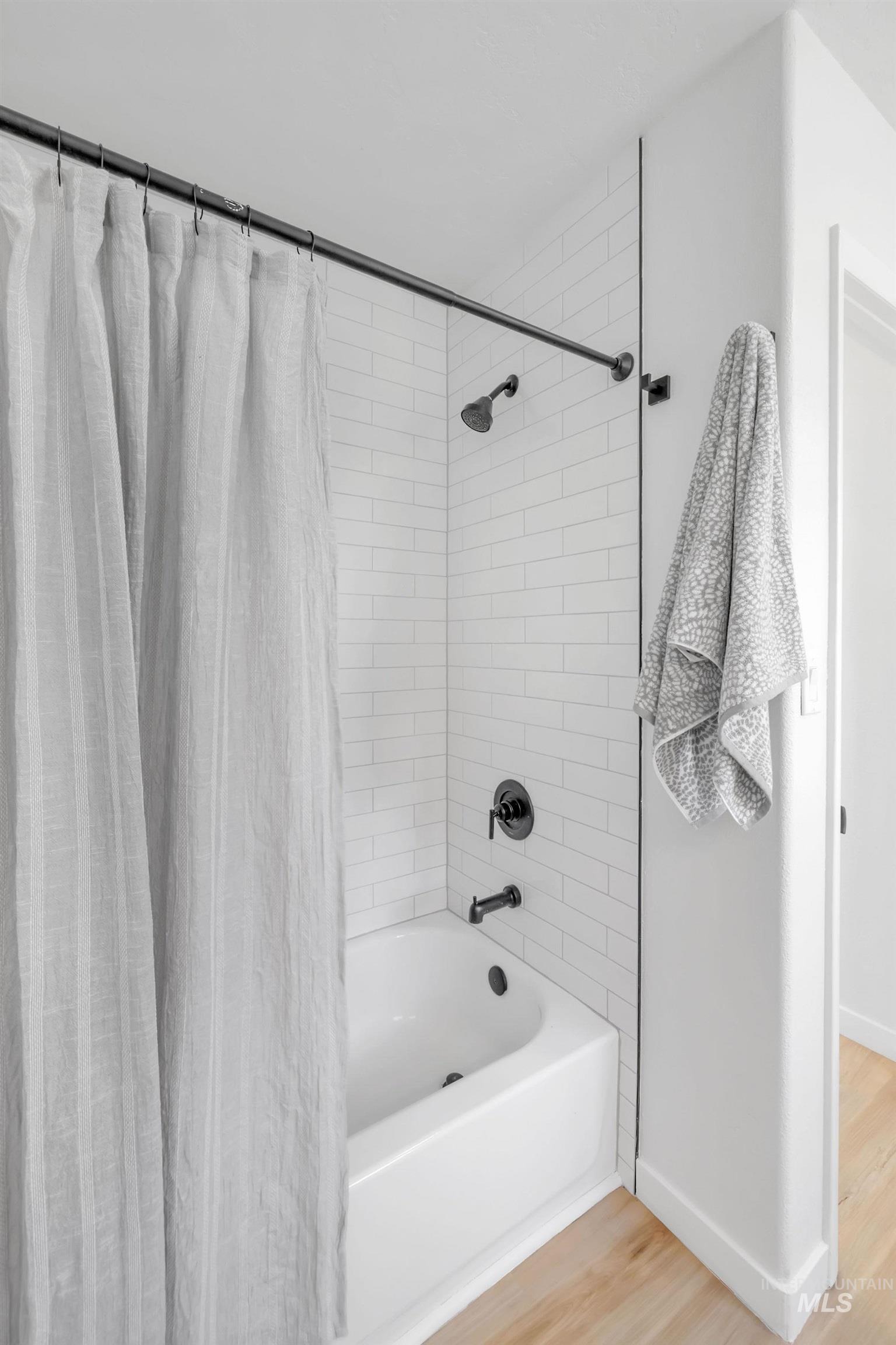 Bathroom featuring wood finished floors and shower / bath combo