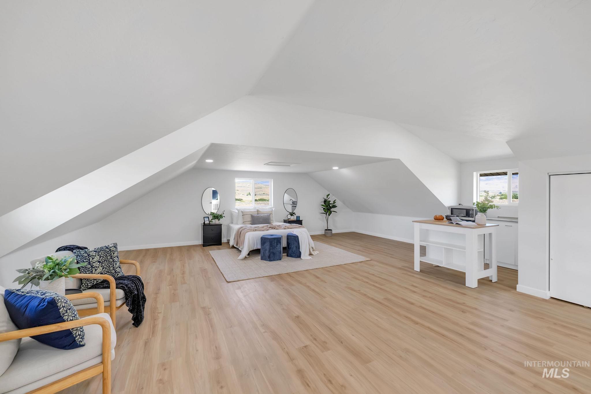 Bedroom with lofted ceiling and wood finished floors