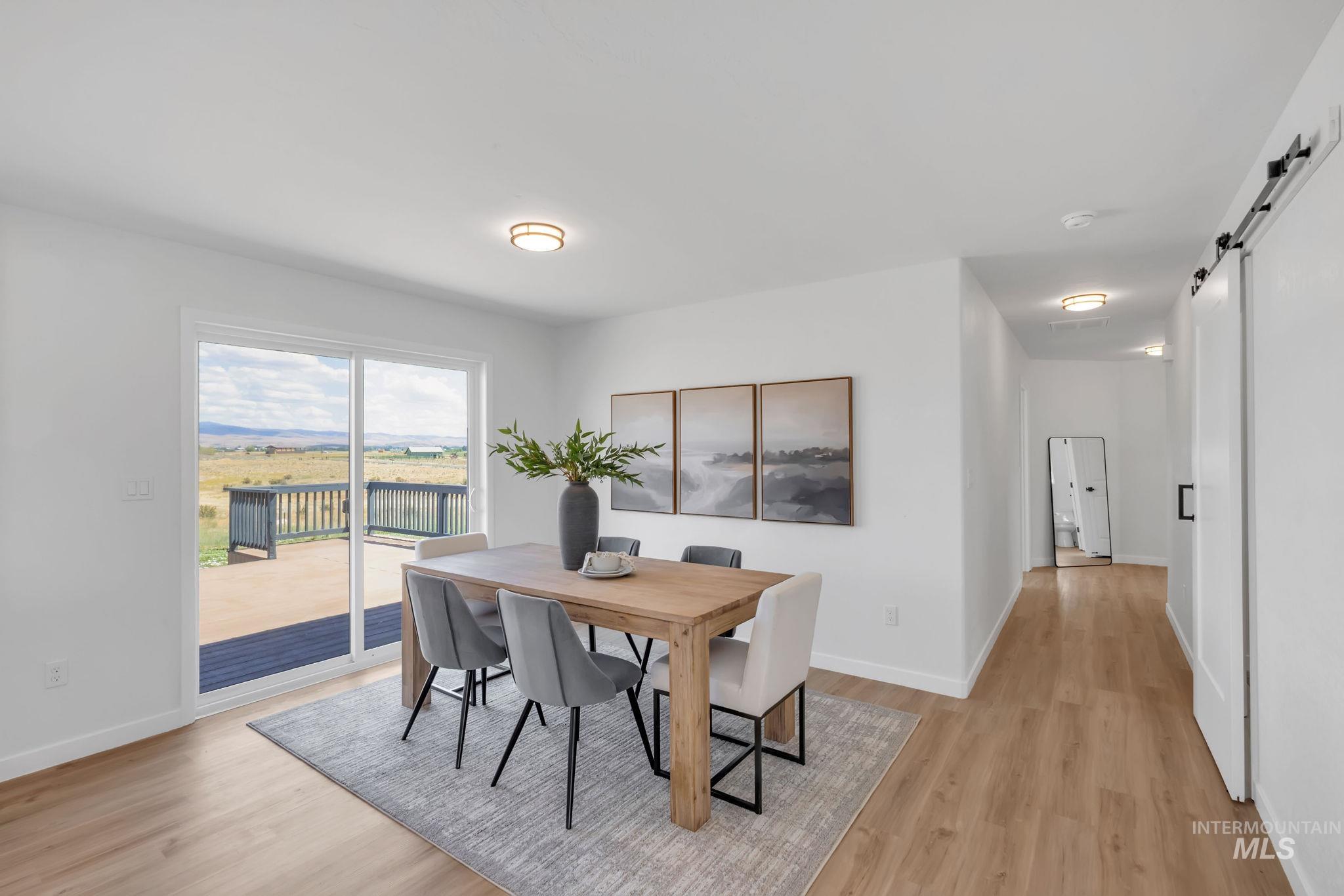 Dining area with a barn door and light wood finished floors